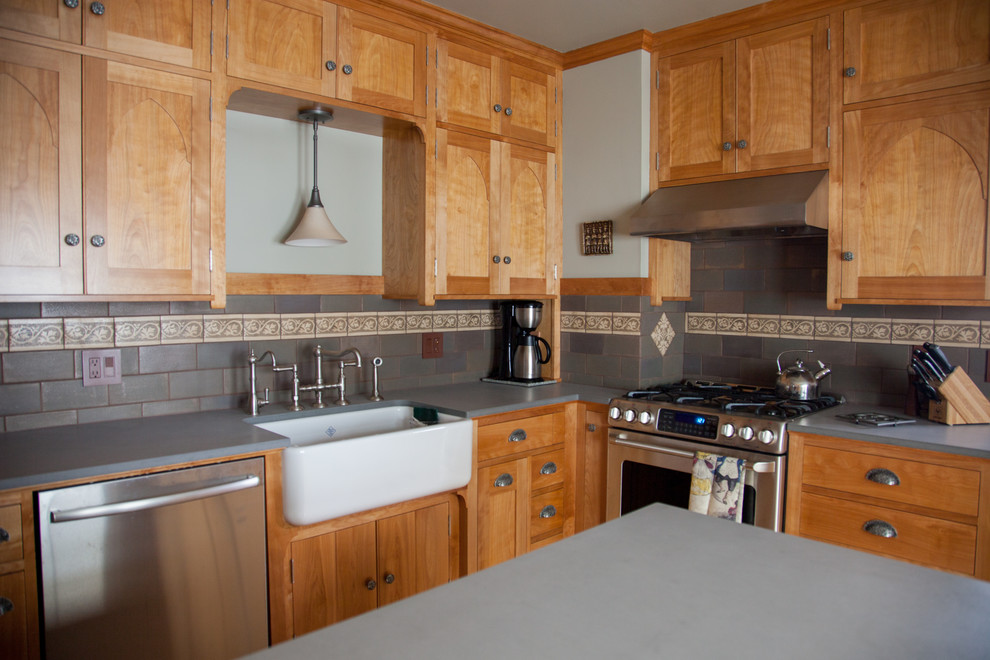 Exempel på ett litet amerikanskt kök, med en rustik diskho, skåp i mellenmörkt trä, bänkskiva i täljsten, grått stänkskydd, stänkskydd i keramik, rostfria vitvaror, luckor med infälld panel, ljust trägolv och en halv köksö