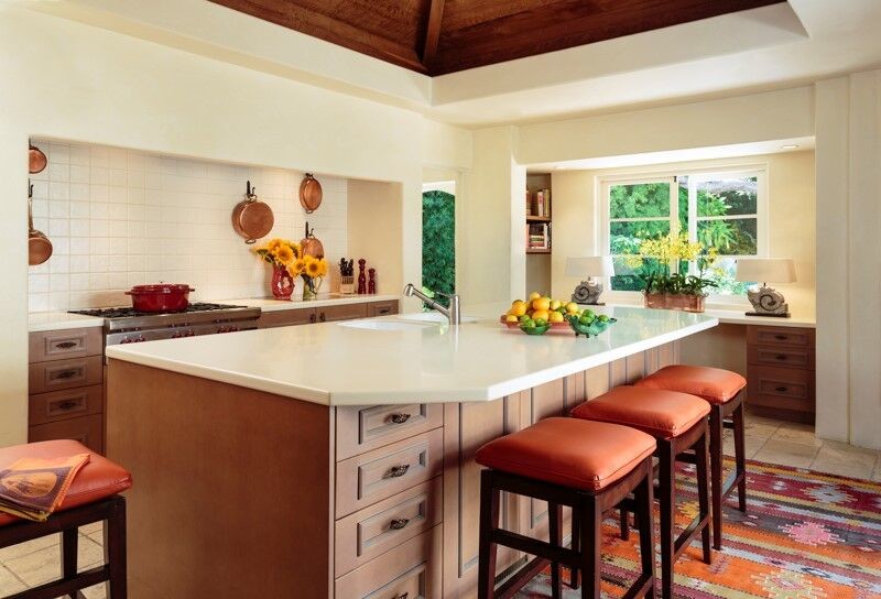 Large classic u-shaped kitchen/diner in Santa Barbara with a double-bowl sink, recessed-panel cabinets, medium wood cabinets, engineered stone countertops, white splashback, porcelain splashback, stainless steel appliances, travertine flooring and an island.