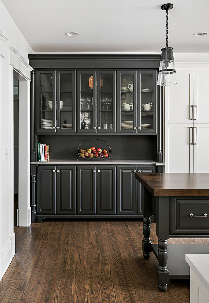 Inspiration for a mid-sized timeless u-shaped dark wood floor and brown floor eat-in kitchen remodel in Chicago with a farmhouse sink, shaker cabinets, white cabinets, quartz countertops, white backsplash, porcelain backsplash, stainless steel appliances and an island
