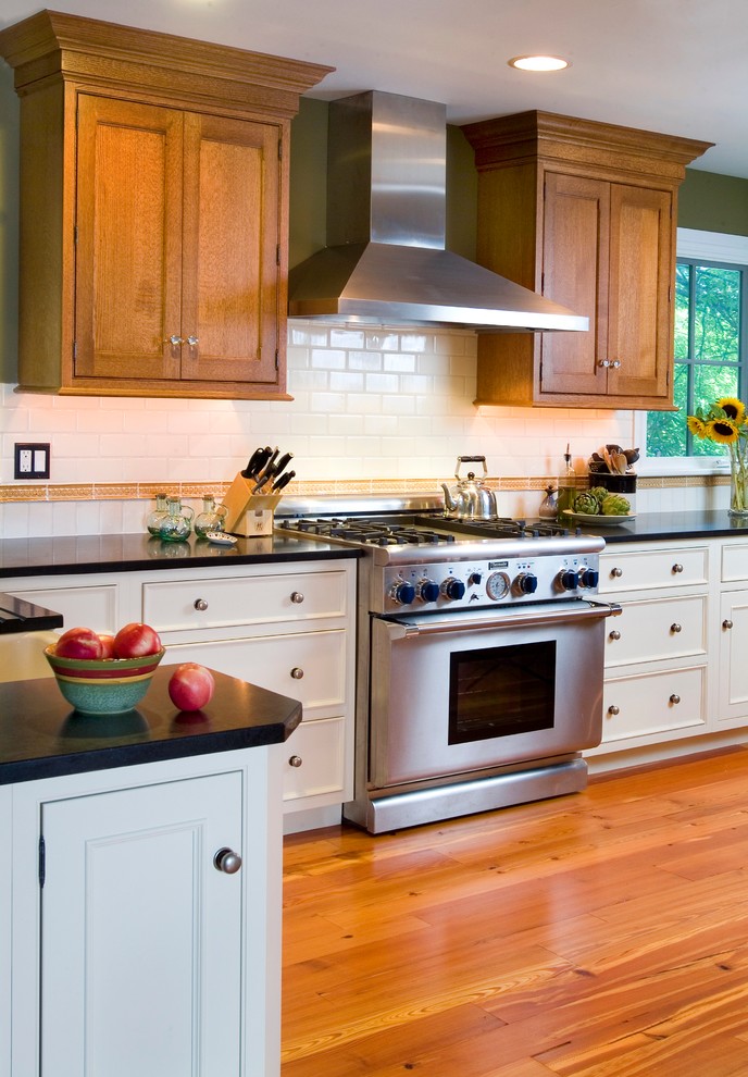 Bild på ett avskilt, mellanstort amerikanskt u-kök, med en rustik diskho, luckor med profilerade fronter, vita skåp, granitbänkskiva, vitt stänkskydd, stänkskydd i keramik, rostfria vitvaror och mellanmörkt trägolv