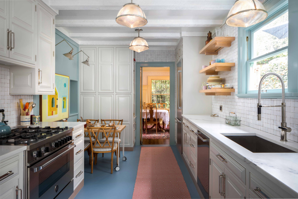 Idéer för vintage vitt kök, med en undermonterad diskho, luckor med upphöjd panel, vita skåp, vitt stänkskydd, rostfria vitvaror och blått golv