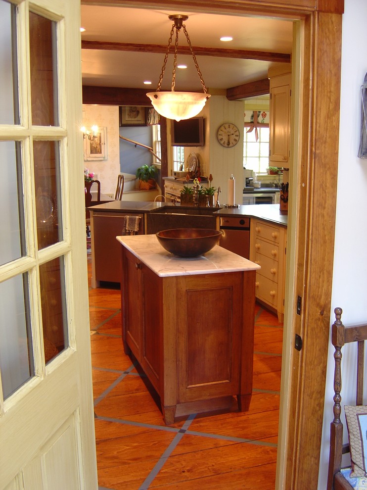 На фото: кухня в стиле кантри с с полувстраиваемой мойкой (с передним бортиком), гранитной столешницей и деревянным полом