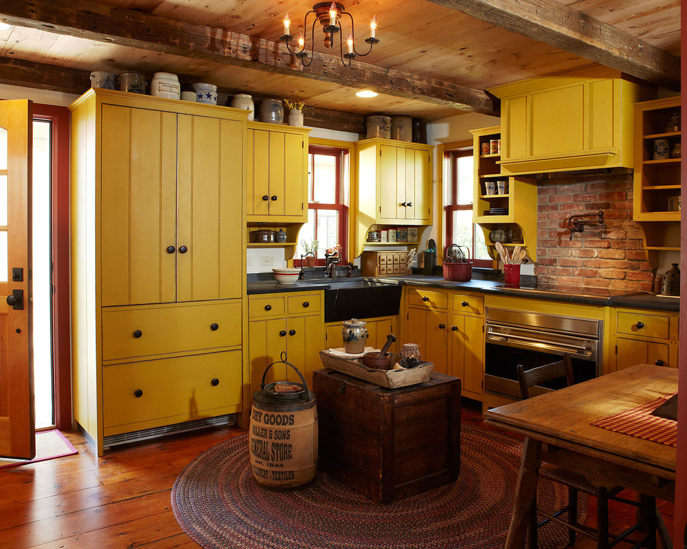 Imagen de cocina campestre con fregadero sobremueble, puertas de armario amarillas, electrodomésticos de colores y suelo de madera en tonos medios