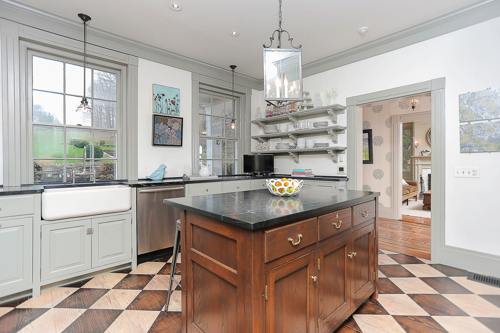 Foto de cocina clásica de tamaño medio con fregadero sobremueble, armarios con paneles lisos, suelo de madera en tonos medios y una isla