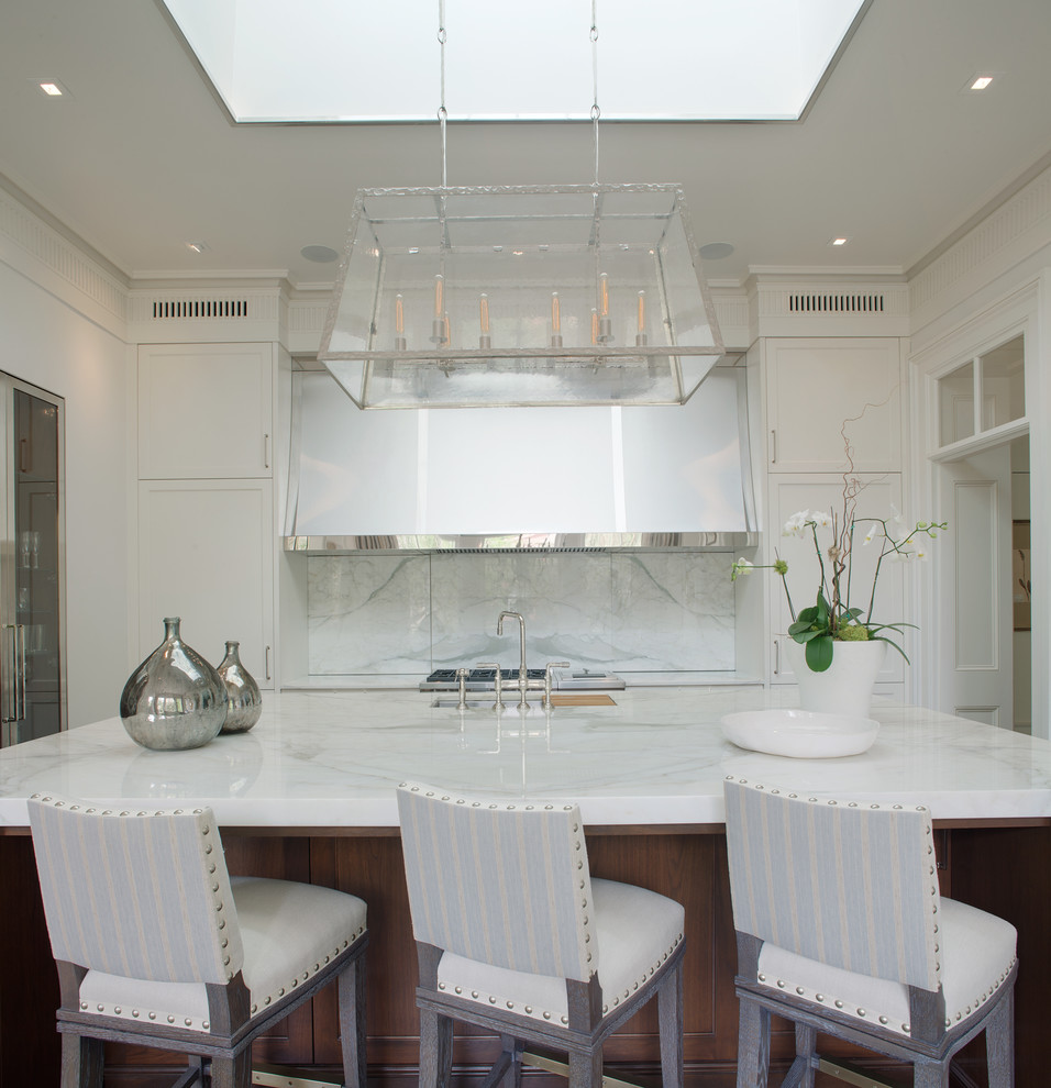 Imagen de cocina clásica con armarios estilo shaker, puertas de armario blancas, salpicadero blanco y una isla