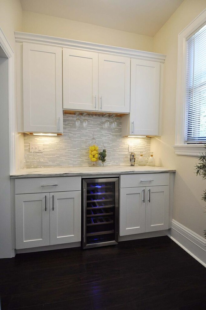 Cette photo montre une petite cuisine moderne avec un placard à porte shaker, des portes de placard blanches, plan de travail en marbre, une crédence blanche, une crédence en mosaïque et parquet foncé.