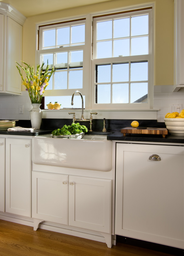 Foto de cocina clásica con encimera de granito, salpicadero blanco, salpicadero de azulejos tipo metro, suelo de madera en tonos medios y electrodomésticos con paneles