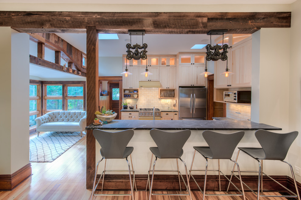 Kitchen - transitional u-shaped kitchen idea in Denver with white cabinets, white backsplash, subway tile backsplash and stainless steel appliances