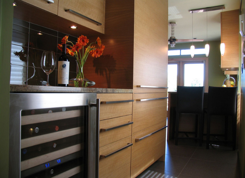 Bild på ett mellanstort funkis kök, med släta luckor, skåp i mellenmörkt trä, granitbänkskiva, brunt stänkskydd, stänkskydd i glaskakel, integrerade vitvaror och en halv köksö