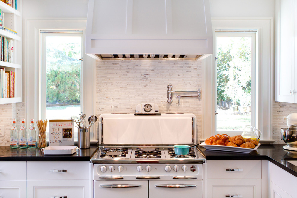 This is an example of a traditional kitchen in Los Angeles with white appliances, white splashback and marble splashback.