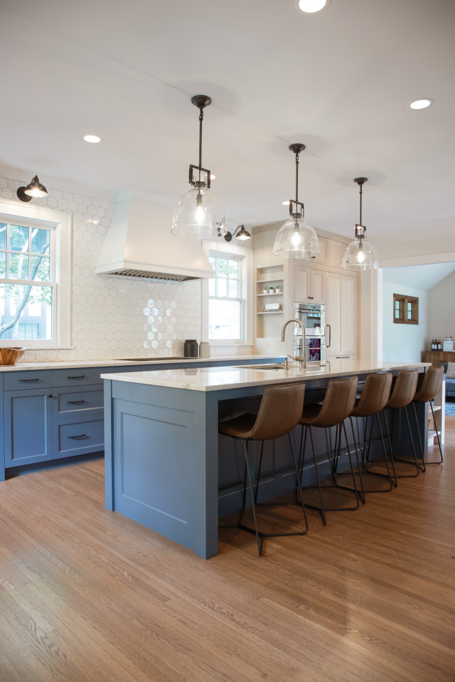 Inspiration for a huge transitional single-wall medium tone wood floor eat-in kitchen remodel in Minneapolis with an undermount sink, recessed-panel cabinets, blue cabinets, granite countertops, white backsplash, ceramic backsplash, paneled appliances, an island and blue countertops