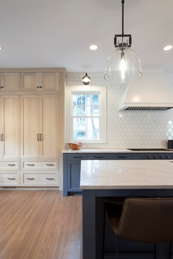 Photo of an expansive traditional single-wall kitchen/diner in Minneapolis with a submerged sink, recessed-panel cabinets, blue cabinets, granite worktops, white splashback, ceramic splashback, integrated appliances, medium hardwood flooring, an island and blue worktops.