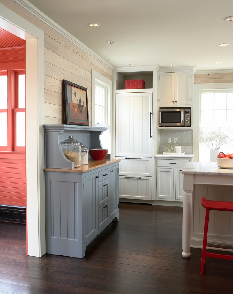 Open concept kitchen - small cottage dark wood floor open concept kitchen idea in Minneapolis with recessed-panel cabinets, white cabinets, marble countertops, gray backsplash, ceramic backsplash, paneled appliances and an island