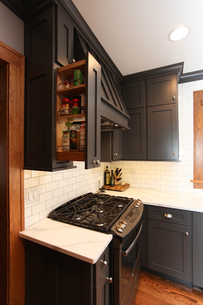 Example of a mid-sized cottage u-shaped medium tone wood floor eat-in kitchen design in Chicago with a farmhouse sink, recessed-panel cabinets, gray cabinets, quartz countertops, white backsplash, subway tile backsplash, colored appliances and a peninsula