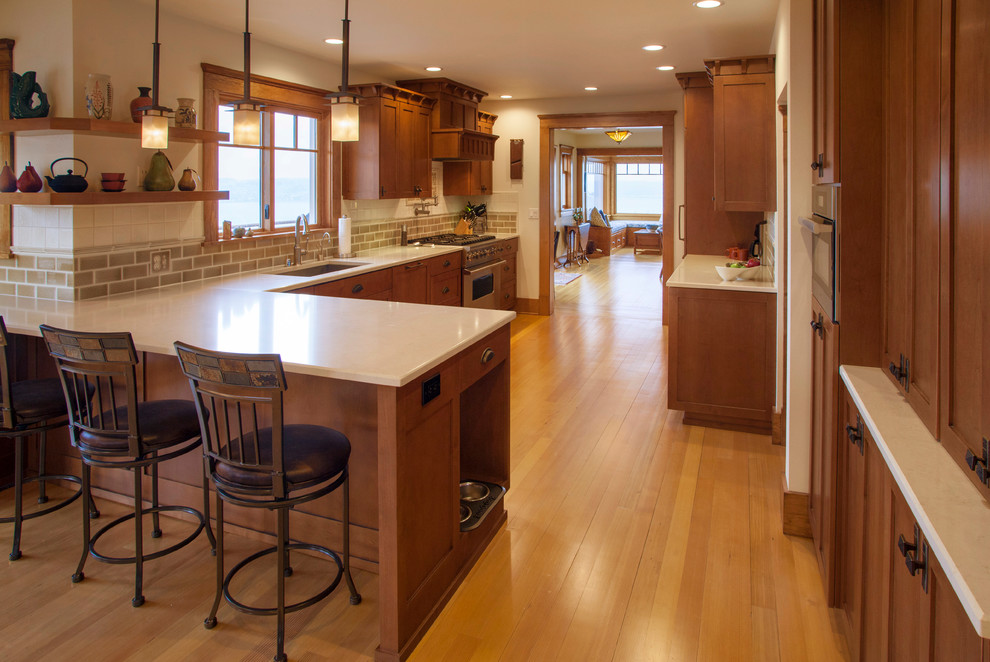 Large classic l-shaped enclosed kitchen in Seattle with a submerged sink, shaker cabinets, medium wood cabinets, engineered stone countertops, stainless steel appliances and medium hardwood flooring.