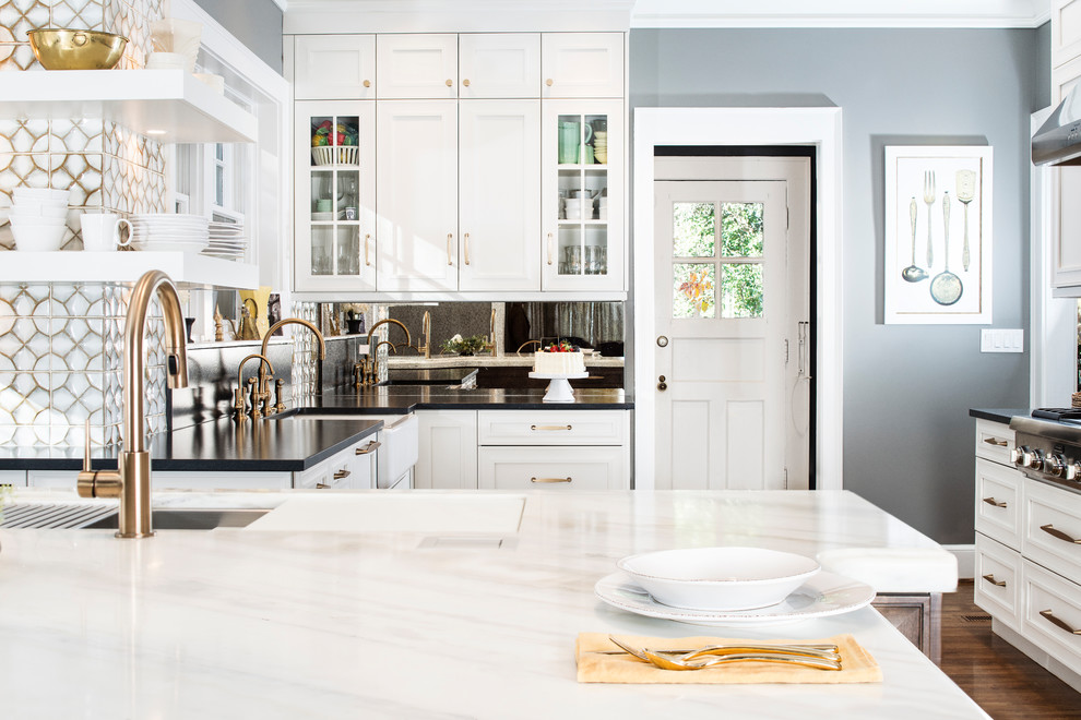 Eat-in kitchen - large transitional u-shaped medium tone wood floor and brown floor eat-in kitchen idea in Other with marble countertops, white backsplash, glass tile backsplash, stainless steel appliances, an island, a farmhouse sink, recessed-panel cabinets and white cabinets