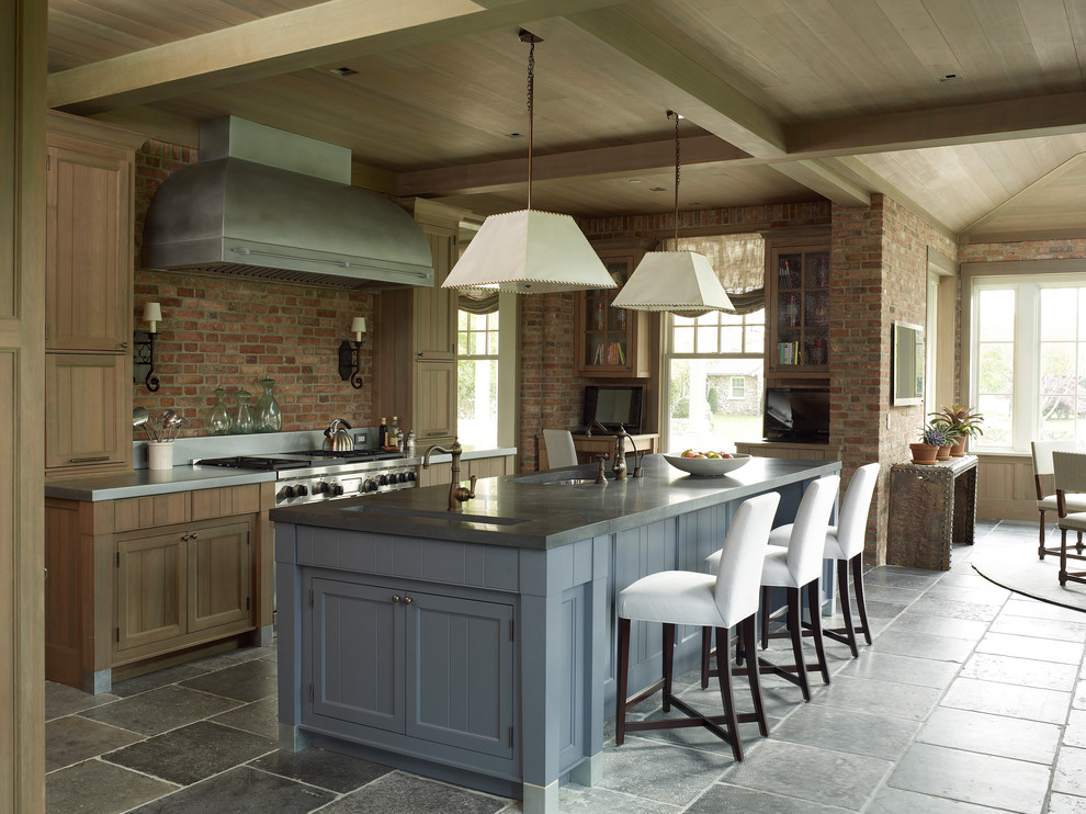 Inredning av ett lantligt stort grå grått kök, med stänkskydd i tegel, rostfria vitvaror, en köksö, grått golv, en undermonterad diskho, skåp i shakerstil, skåp i mellenmörkt trä och rött stänkskydd