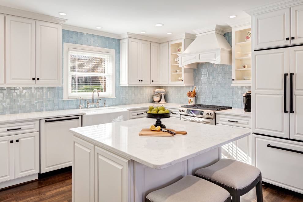 Exempel på ett mellanstort klassiskt kök, med en rustik diskho, luckor med upphöjd panel, vita skåp, bänkskiva i kvarts, blått stänkskydd, stänkskydd i porslinskakel, integrerade vitvaror, mellanmörkt trägolv, en köksö och brunt golv