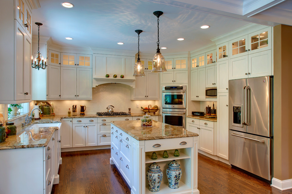 Ejemplo de cocina comedor clásica con fregadero integrado, armarios con paneles lisos, puertas de armario blancas, encimera de granito y electrodomésticos de acero inoxidable