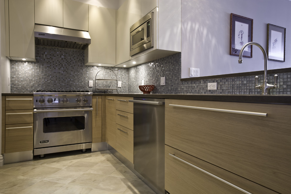 Ejemplo de cocina contemporánea con electrodomésticos de acero inoxidable, armarios con paneles lisos, puertas de armario de madera oscura, salpicadero azul y salpicadero con mosaicos de azulejos