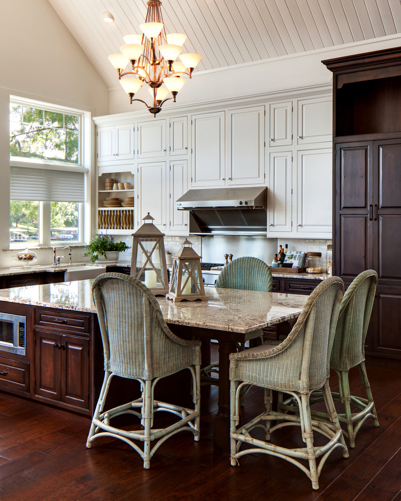 Eat-in kitchen - mid-sized traditional u-shaped dark wood floor and brown floor eat-in kitchen idea in Houston with a farmhouse sink, beaded inset cabinets, granite countertops, white backsplash, subway tile backsplash, stainless steel appliances, white cabinets, an island and brown countertops