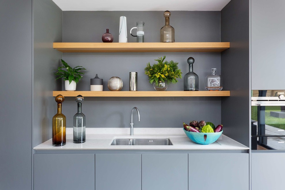 Immagine di una cucina design di medie dimensioni con ante lisce, elettrodomestici in acciaio inossidabile e parquet chiaro