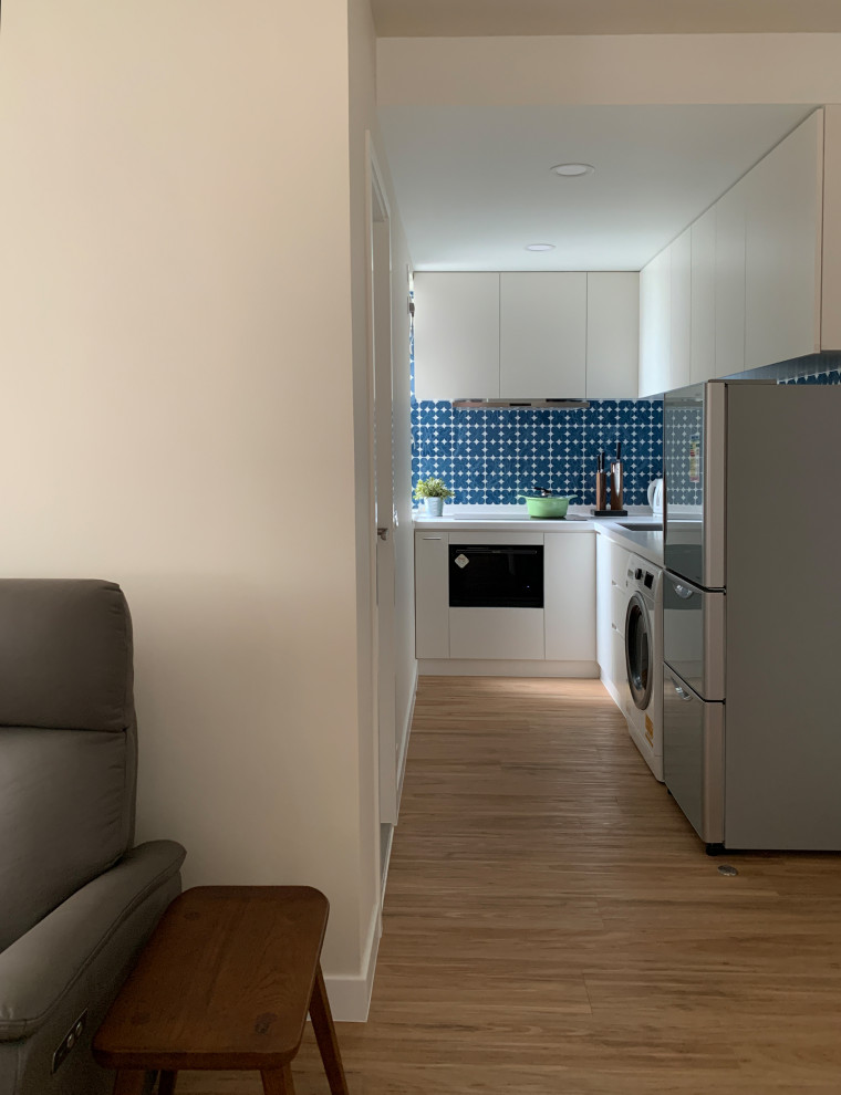 Design ideas for a small modern l-shaped kitchen pantry in Hong Kong with a submerged sink, flat-panel cabinets, medium wood cabinets, blue splashback, porcelain splashback, stainless steel appliances, vinyl flooring, brown floors and white worktops.