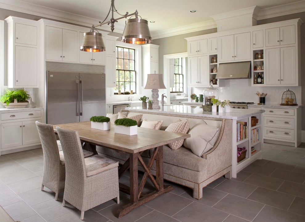 Large elegant u-shaped porcelain tile and gray floor kitchen photo in Houston with stainless steel appliances, an undermount sink, shaker cabinets, white cabinets, granite countertops, white backsplash, subway tile backsplash and an island