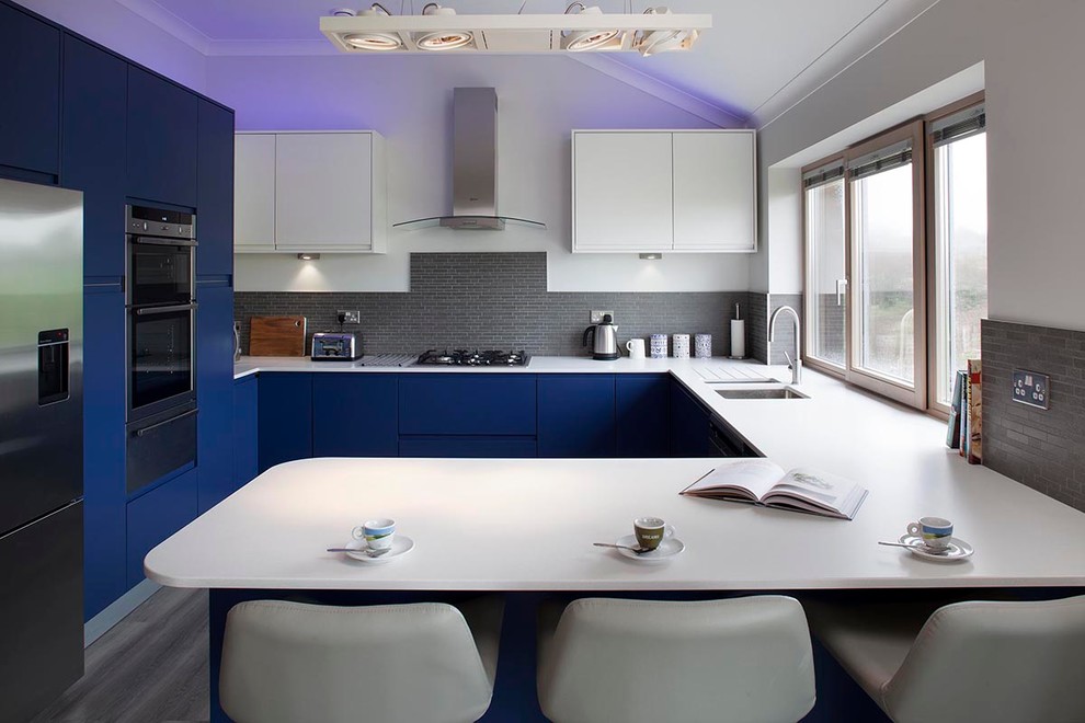 Offene, Kleine Moderne Küche in L-Form mit Waschbecken, flächenbündigen Schrankfronten, weißen Schränken, Laminat-Arbeitsplatte, Vinylboden und Kücheninsel in Cornwall