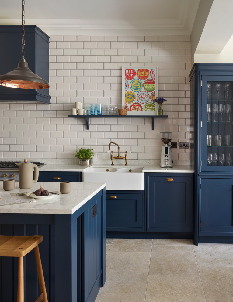 Kitchen - mid-sized transitional kitchen idea in Sussex with a farmhouse sink, white backsplash, subway tile backsplash, stainless steel appliances and an island