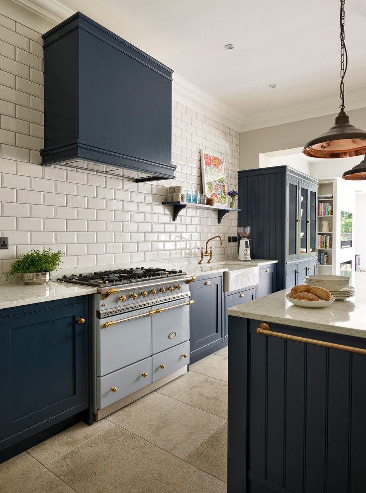 Inspiration for a mid-sized transitional kitchen remodel in Sussex with a farmhouse sink, white backsplash, subway tile backsplash, stainless steel appliances and an island
