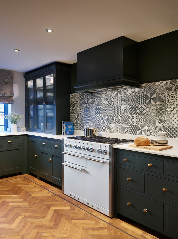 This is an example of a medium sized classic u-shaped enclosed kitchen in Essex with a belfast sink, green cabinets, engineered stone countertops, grey splashback, ceramic splashback, white appliances and no island.