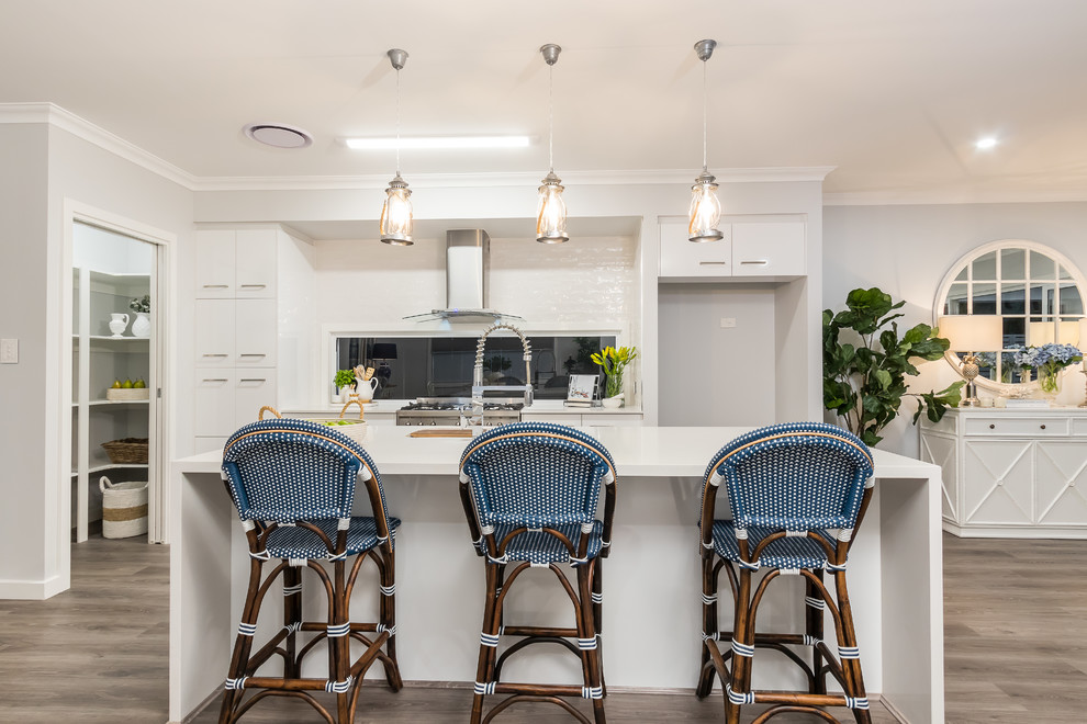 Photo of a large beach style kitchen in Brisbane with flat-panel cabinets, white cabinets, engineered stone countertops, white worktops, window splashback, dark hardwood flooring and an island.
