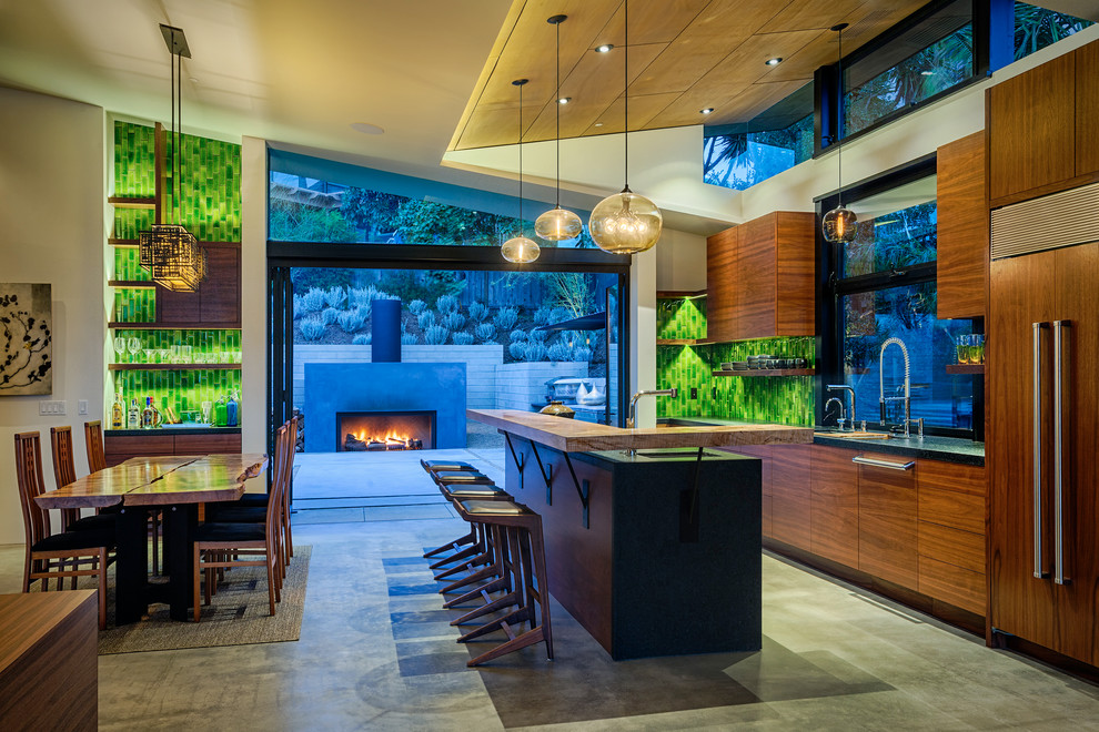 Zweizeilige Moderne Küche mit flächenbündigen Schrankfronten, hellbraunen Holzschränken, Betonboden und Kücheninsel in San Diego