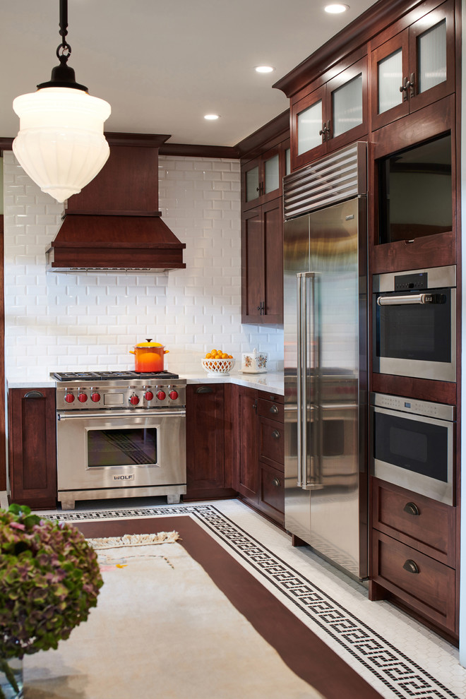 Inspiration for a mid-sized craftsman u-shaped ceramic tile and white floor enclosed kitchen remodel in Los Angeles with a farmhouse sink, shaker cabinets, brown cabinets, marble countertops, white backsplash, ceramic backsplash, stainless steel appliances, no island and gray countertops