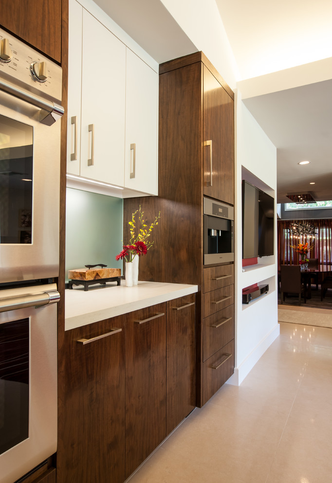 Foto di una cucina minimalista con ante lisce, ante in legno bruno, top in quarzo composito, paraspruzzi con lastra di vetro e elettrodomestici in acciaio inossidabile