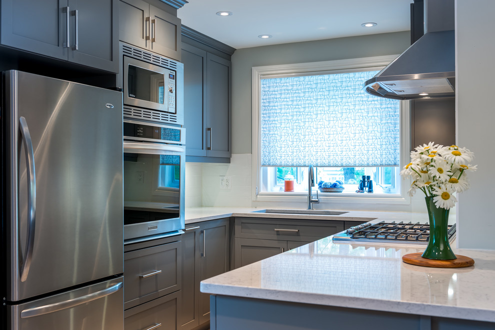 Design ideas for a small contemporary galley enclosed kitchen in Ottawa with a submerged sink, recessed-panel cabinets, grey cabinets, quartz worktops, white splashback, ceramic splashback, stainless steel appliances, cork flooring and a breakfast bar.