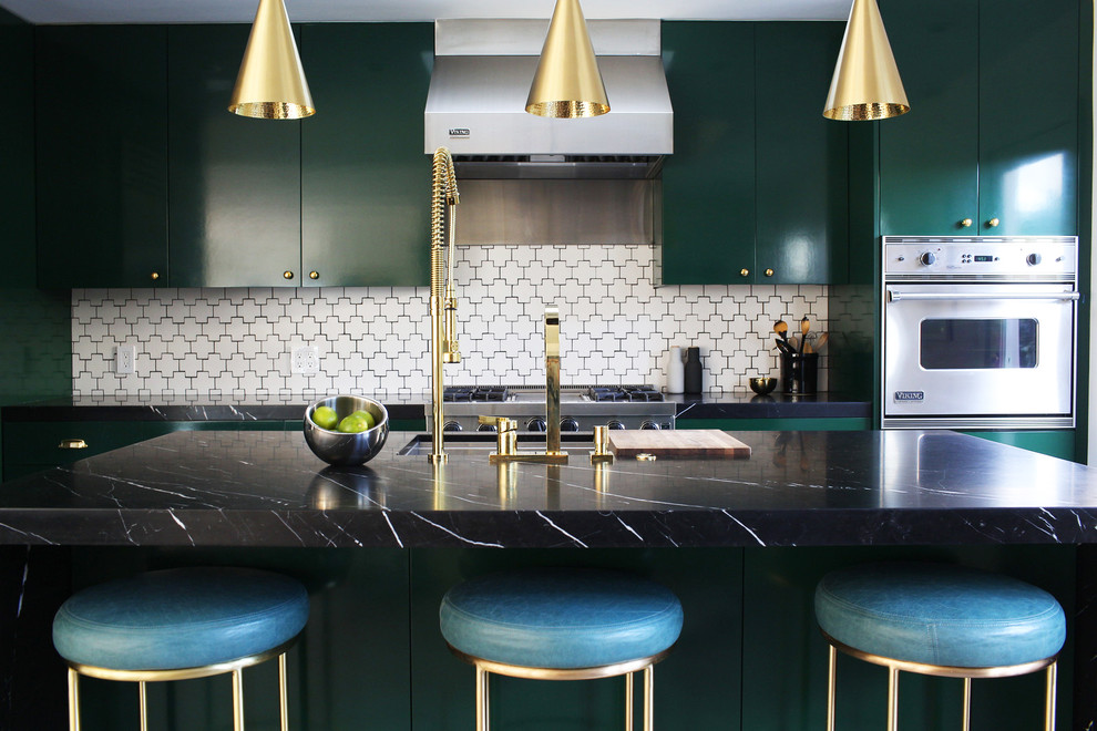 Photo of a contemporary galley open plan kitchen in Los Angeles with a submerged sink, flat-panel cabinets, green cabinets, marble worktops, white splashback, ceramic splashback, stainless steel appliances, an island and black worktops.