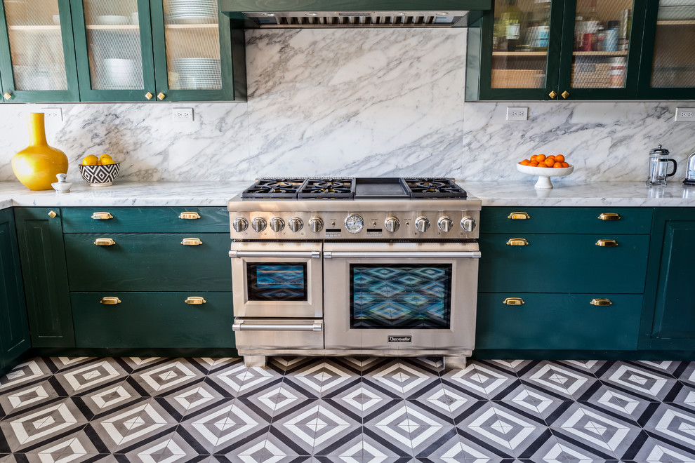 Photo of a large bohemian l-shaped kitchen/diner in Los Angeles with a submerged sink, raised-panel cabinets, green cabinets, marble worktops, white splashback, marble splashback, stainless steel appliances, cement flooring, no island and black floors.