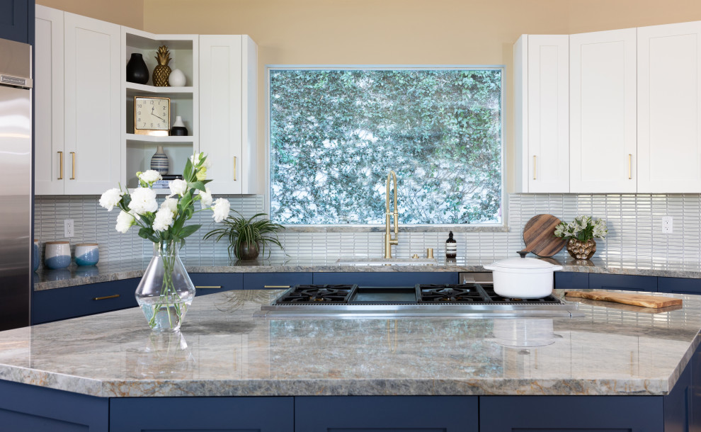 Klassisk inredning av ett mycket stort grå grått u-kök, med en enkel diskho, skåp i shakerstil, blå skåp, bänkskiva i kvartsit, vitt stänkskydd, stänkskydd i porslinskakel, rostfria vitvaror, ljust trägolv och en köksö
