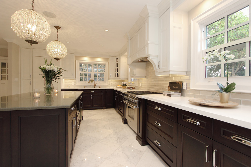 Exempel på ett stort klassiskt vit vitt kök och matrum, med en undermonterad diskho, luckor med infälld panel, bruna skåp, bänkskiva i kvarts, beige stänkskydd, stänkskydd i glaskakel, integrerade vitvaror, marmorgolv, en köksö och vitt golv