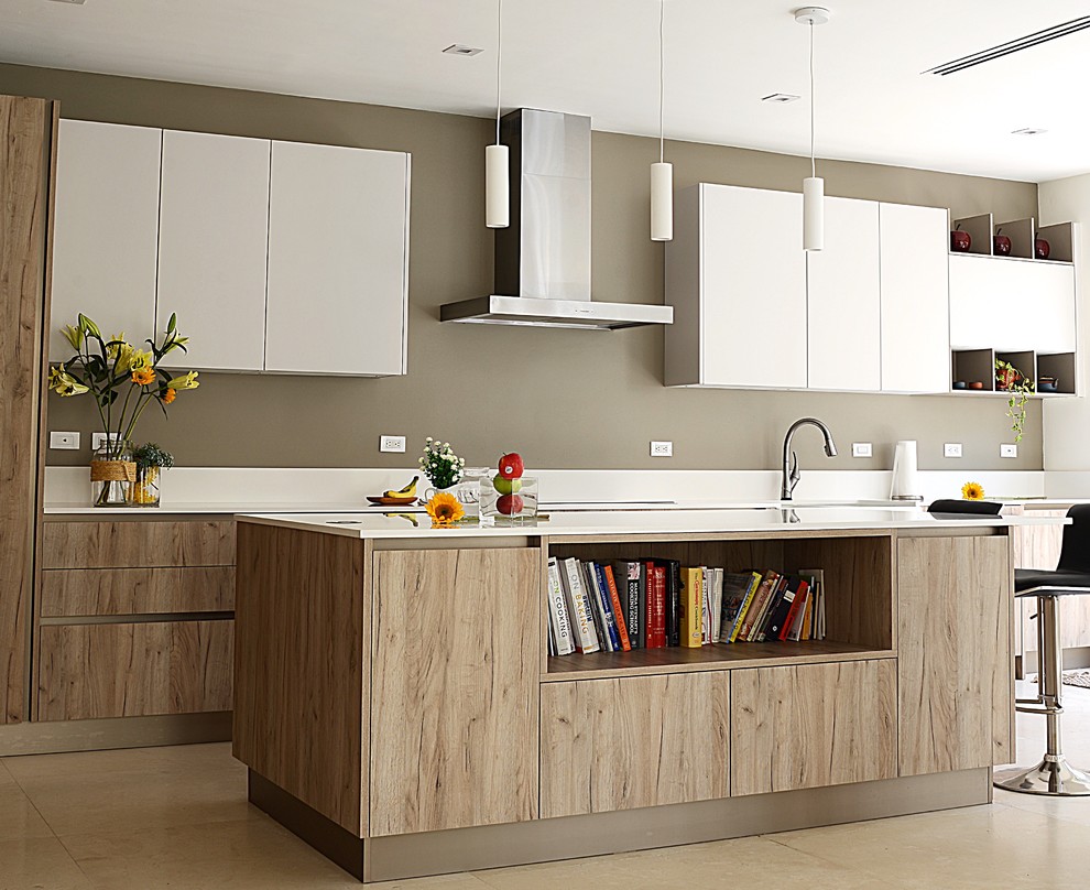 Photo of a kitchen/diner in Miami with a double-bowl sink, flat-panel cabinets, light wood cabinets, white splashback, stainless steel appliances, ceramic flooring, an island, beige floors and white worktops.