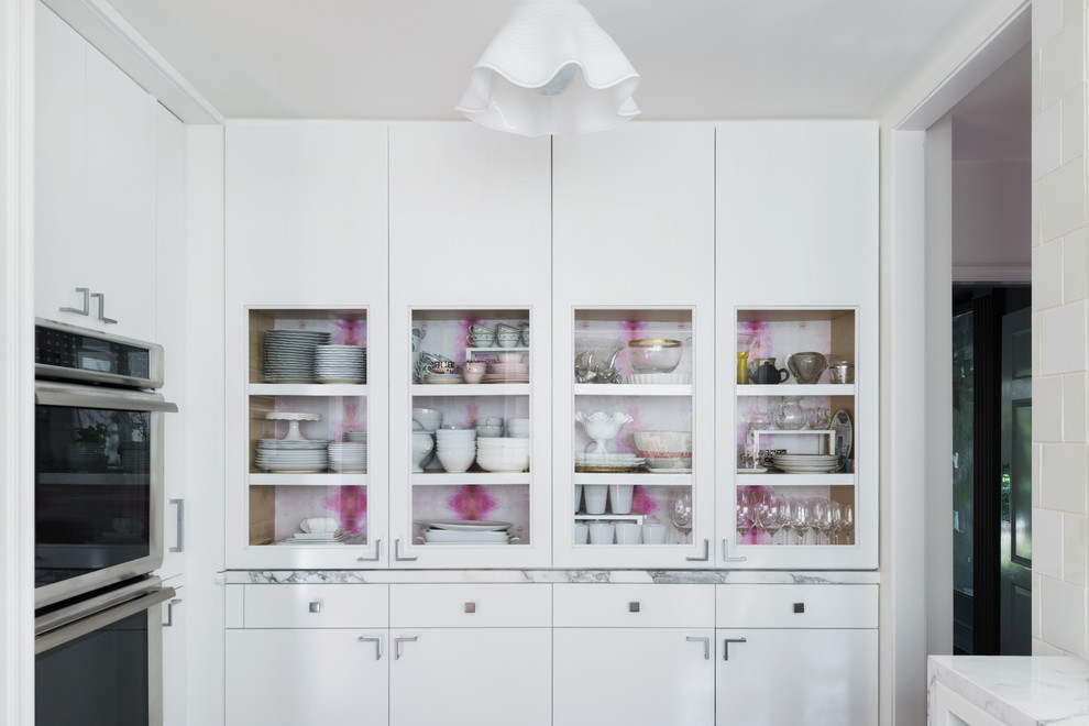 This is an example of a large classic l-shaped kitchen in Los Angeles with glass-front cabinets, white cabinets, marble worktops and no island.