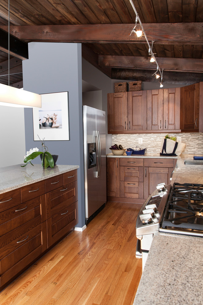 Foto på ett mellanstort retro kök, med en undermonterad diskho, luckor med upphöjd panel, skåp i mellenmörkt trä, bänkskiva i koppar, grått stänkskydd, stänkskydd i mosaik, rostfria vitvaror, ljust trägolv och en halv köksö
