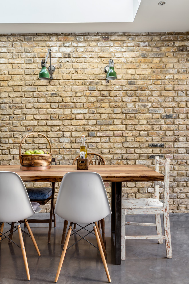 Example of a mid-sized trendy concrete floor dining room design in London