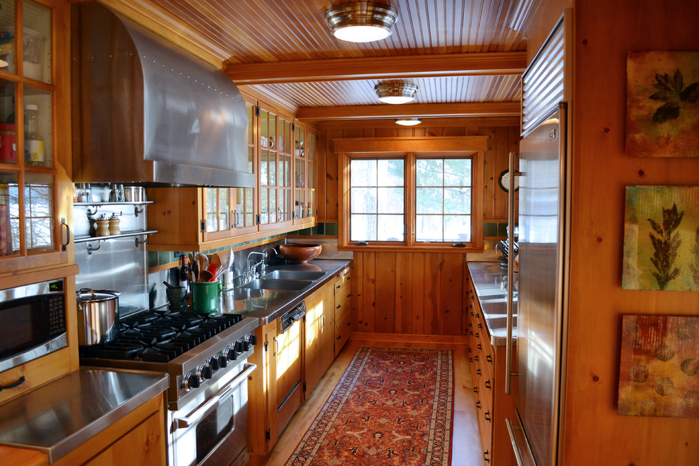 Photo of a traditional kitchen in Minneapolis with glass-front cabinets, stainless steel appliances, stainless steel worktops and an integrated sink.