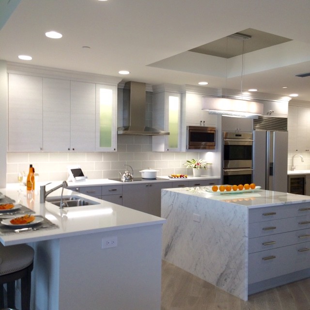 Inspiration for a large eclectic u-shaped light wood floor eat-in kitchen remodel in Tampa with an undermount sink, flat-panel cabinets, gray cabinets, marble countertops, subway tile backsplash, stainless steel appliances and an island
