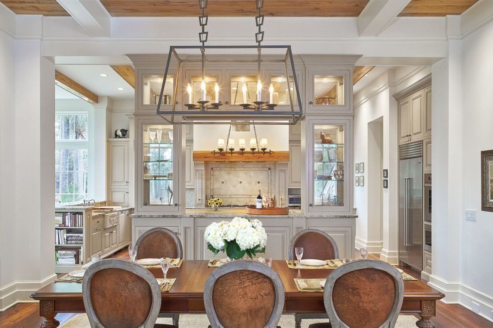 Eat-in kitchen - large traditional u-shaped medium tone wood floor eat-in kitchen idea in Atlanta with a farmhouse sink, raised-panel cabinets, gray cabinets, granite countertops, beige backsplash, stone tile backsplash, stainless steel appliances and two islands