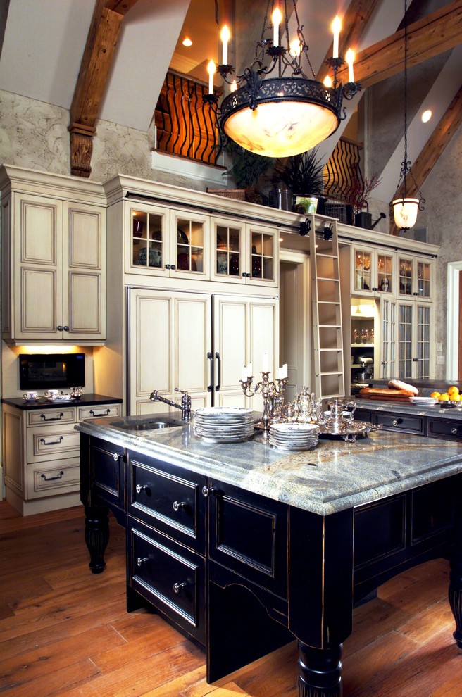 Modelo de cocina clásica grande con encimera de zinc, electrodomésticos de acero inoxidable, suelo de madera clara y dos o más islas