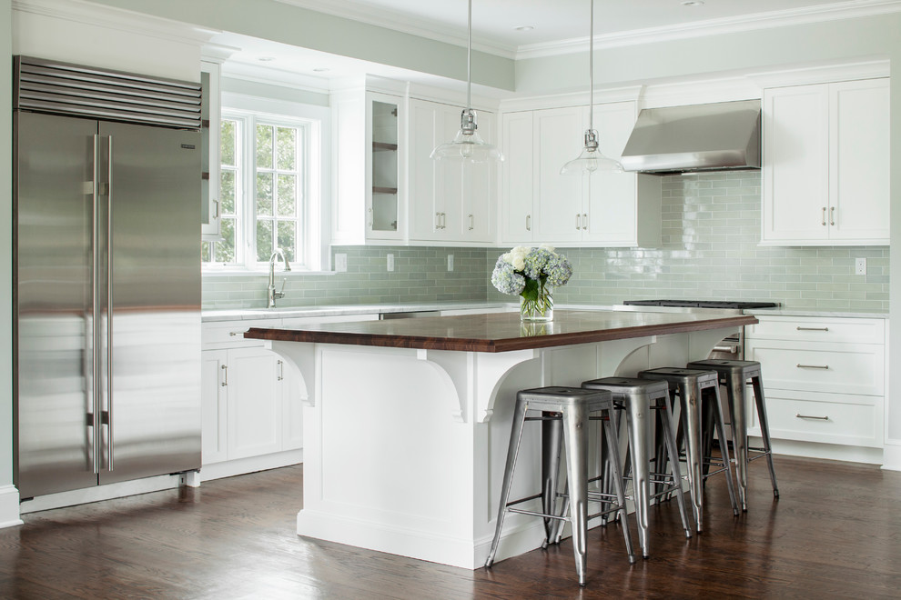 Contemporary l-shaped kitchen/diner in New York with a double-bowl sink, recessed-panel cabinets, yellow cabinets, granite worktops, green splashback, ceramic splashback, stainless steel appliances, dark hardwood flooring and an island.
